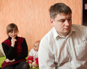 photo: baby sits by troubled parents contemplating separation