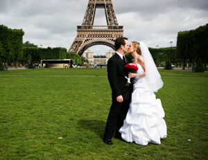 photo: American and French bride and groom at Eiffel tower in Paris