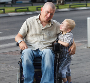 photo: young boy with disabled father in wheelchair